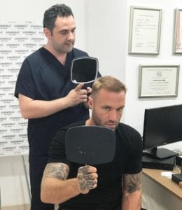 Dr. Levent Acar showing Calum Best the hair transplant turkey result
