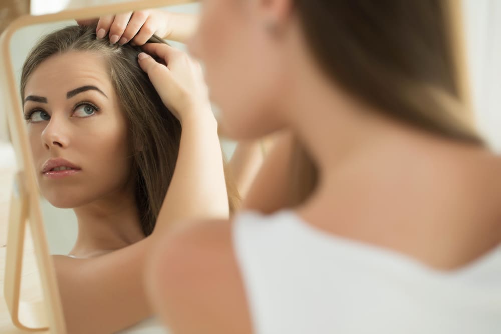 Женщина осматривает волосы