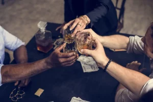 People toasting with glasses of alcohol over table