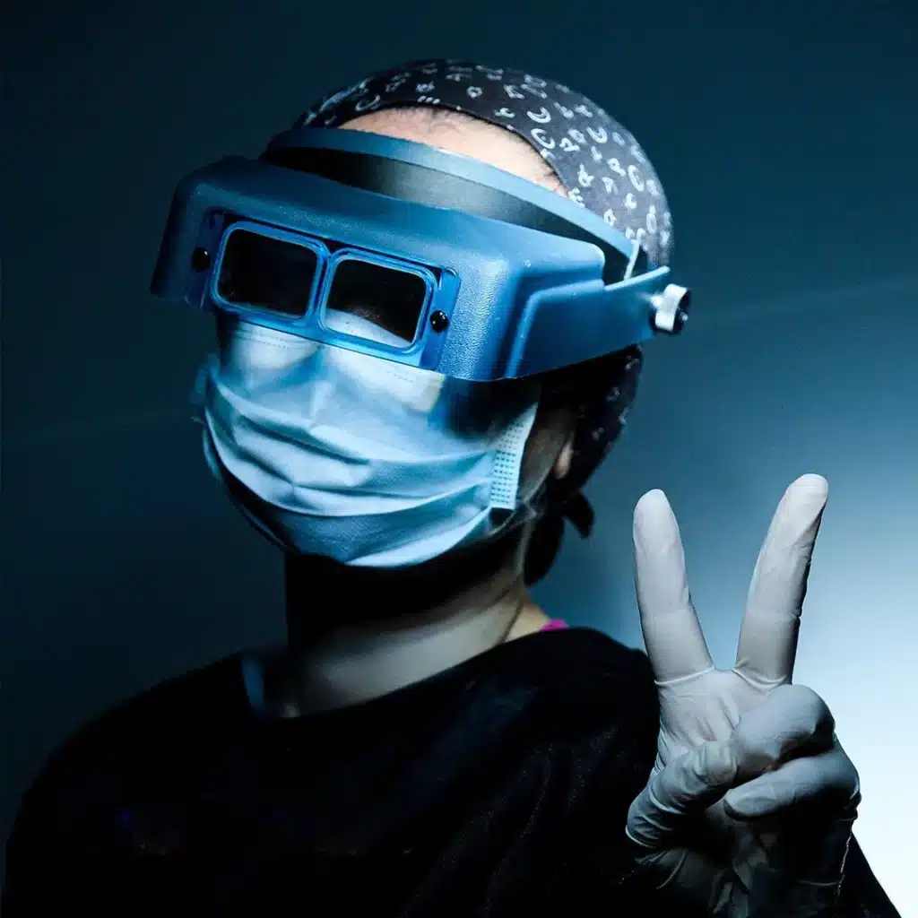 Cosmedica team member in surgical gear throwing a V sign