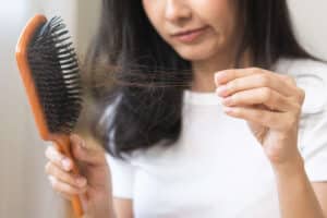 Woman looking at the hairs she's losing