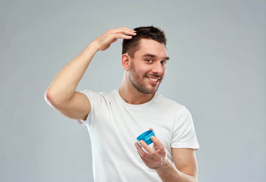 Jeune homme se coiffant avec du gel pour cheveux