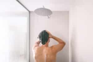 Man taking a shower with hard water