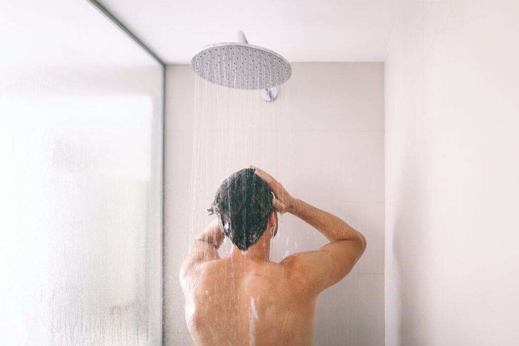 Homme prenant une douche et se lavant les cheveux