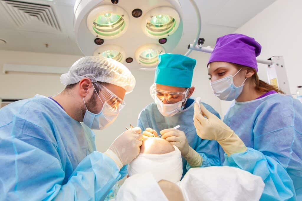 Baldness treatment. Hair transplant. Surgeons in the operating room carry out hair transplant surgery.