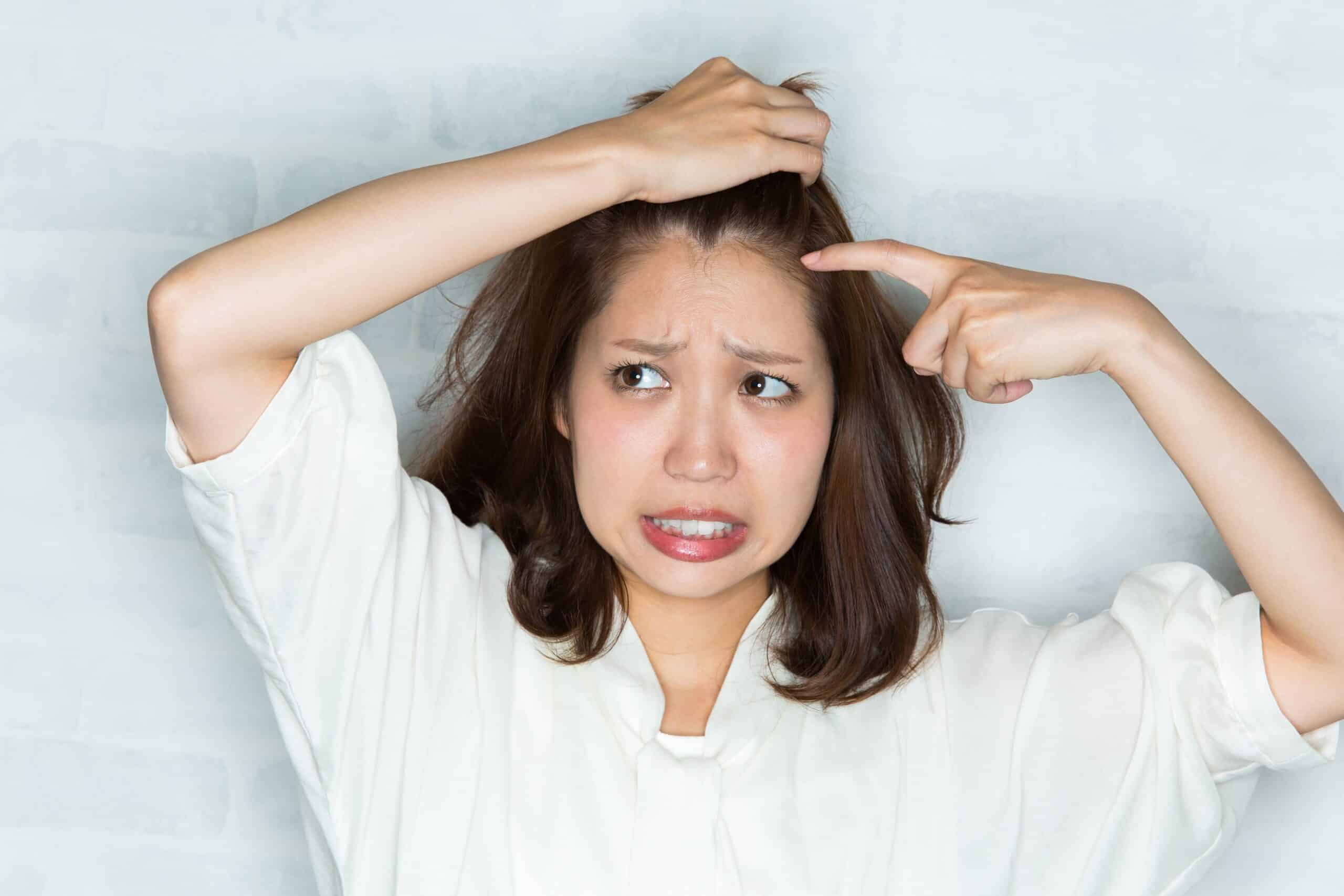 Femme avec boutons sur le cuir chevelu