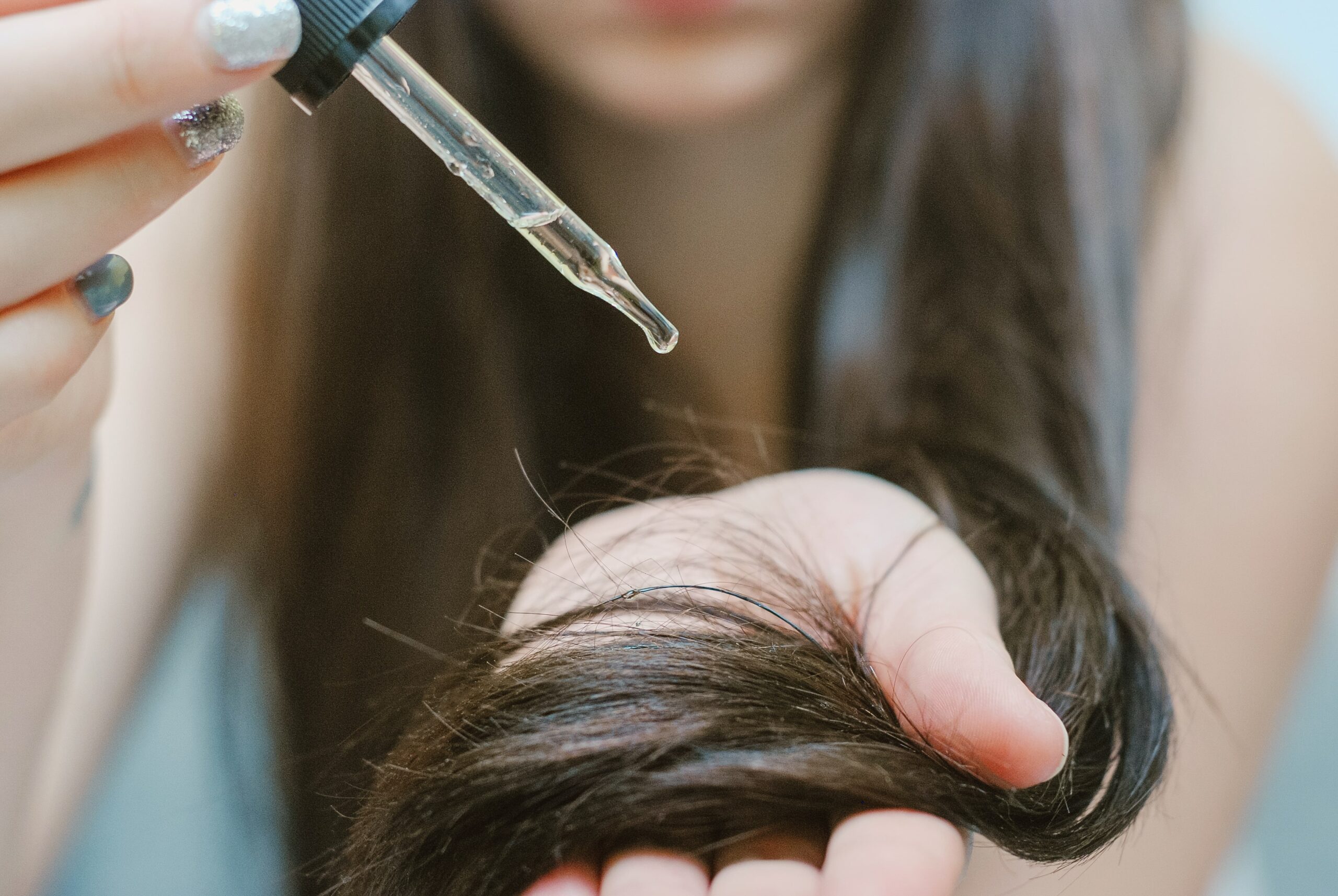 Woman applying castor oil on her hair