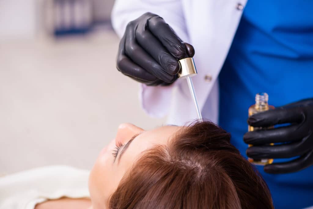 Mujer joven visitando a un esteticista en un centro de trasplante capilar