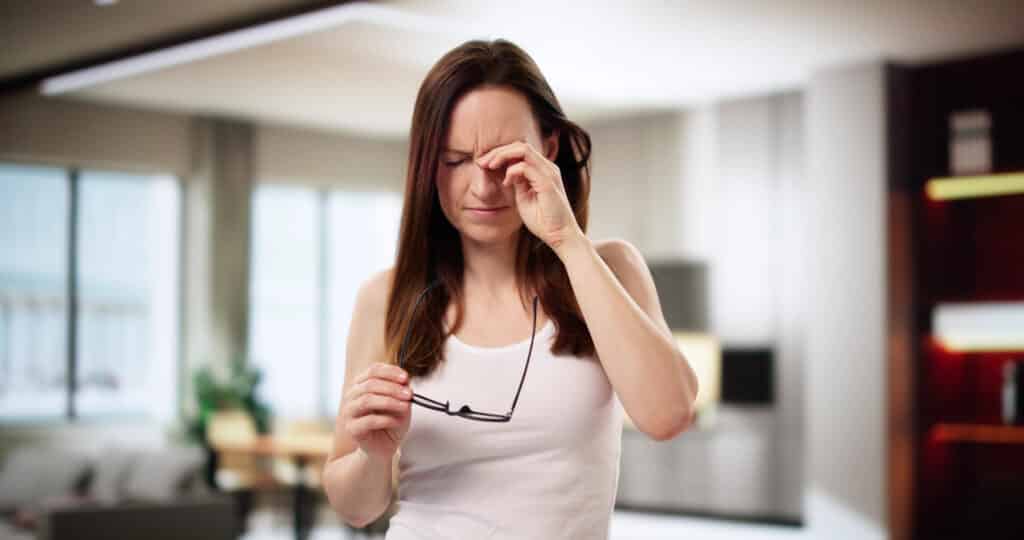 Una mujer preocupada se rasca los ojos