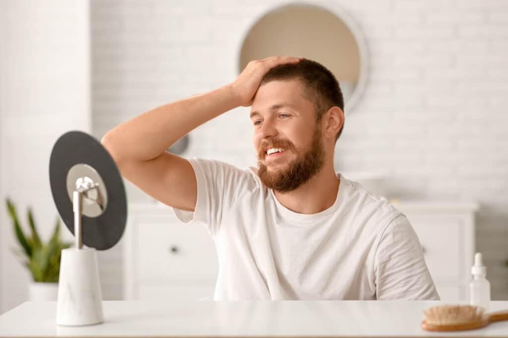 Uomo si guarda allo specchio e sorride