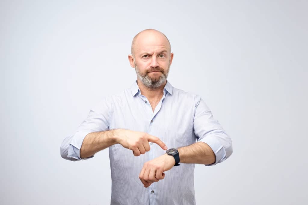 Hombre señalando su reloj
