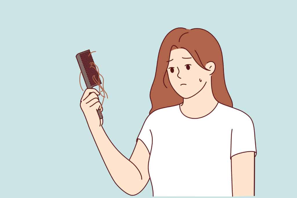 Mujer observa peine con pelo perdido