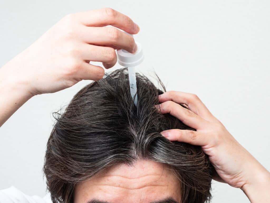 Hombre usando gotas para el pelo