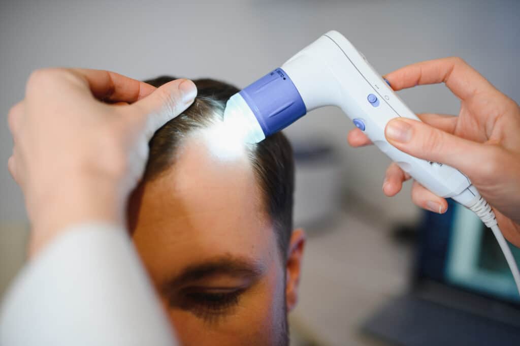 Un médico examina el cabello de un hombre