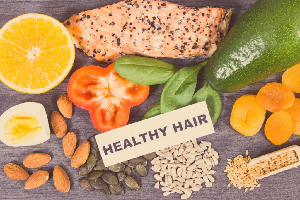 Diversi prodotti o ingredienti nutrienti contenenti vitamine e minerali per capelli sani e rigogliosi