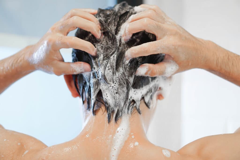Hombre lavándose el pelo con champú