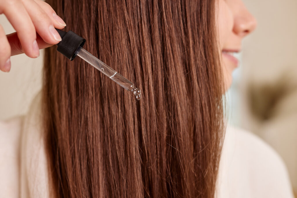Donna applica gocce per capelli