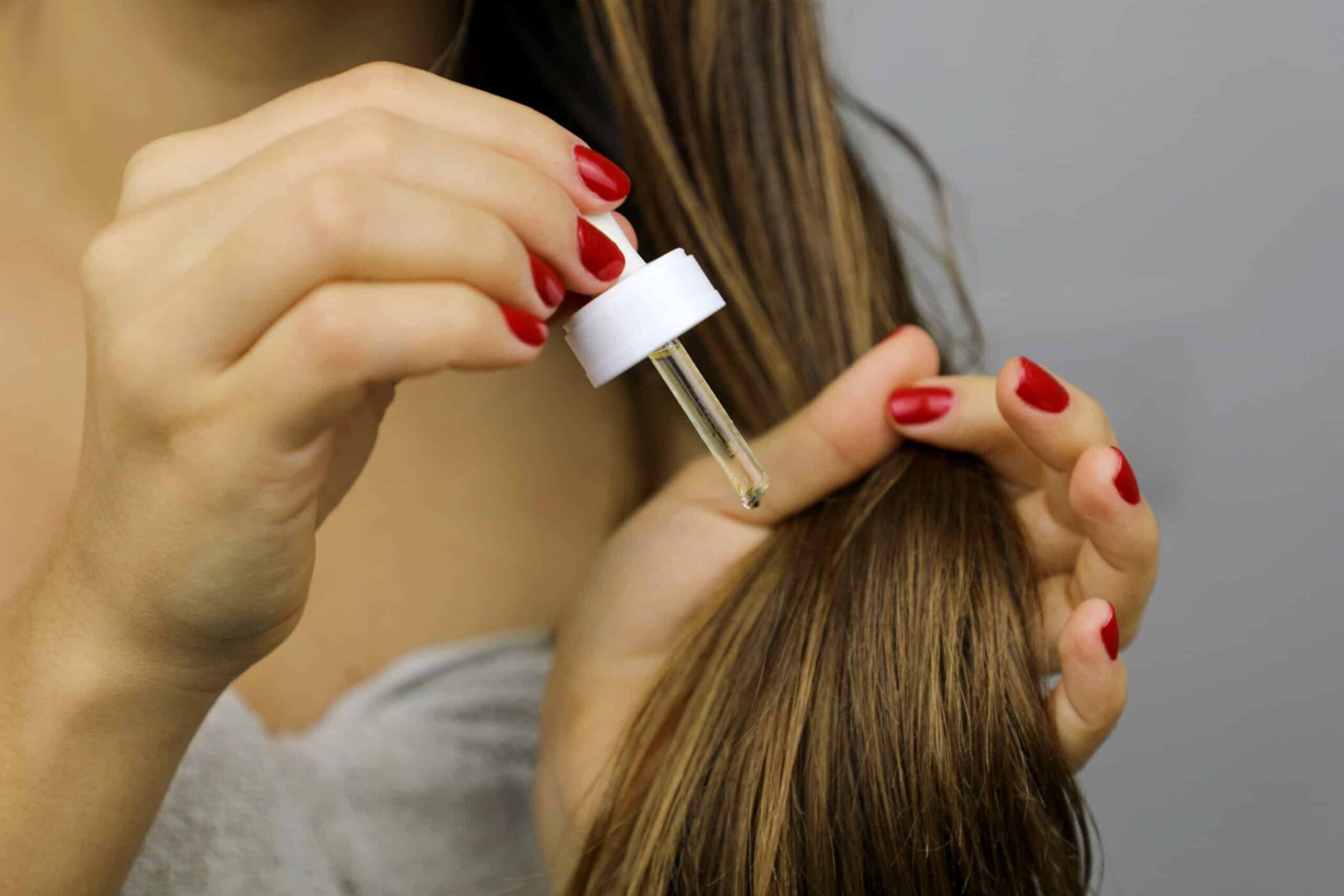 Mujer aplicando aceite de argán sobre cabello seco