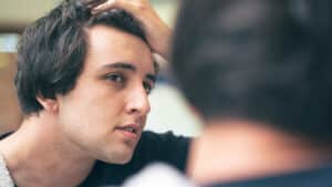 Ragazzo di 20 anni controlla i propri capelli