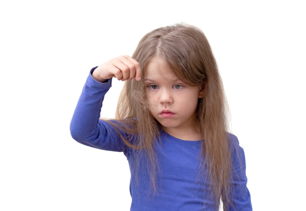 Fille avec perte de cheveux enfant observant ses mèches tombées