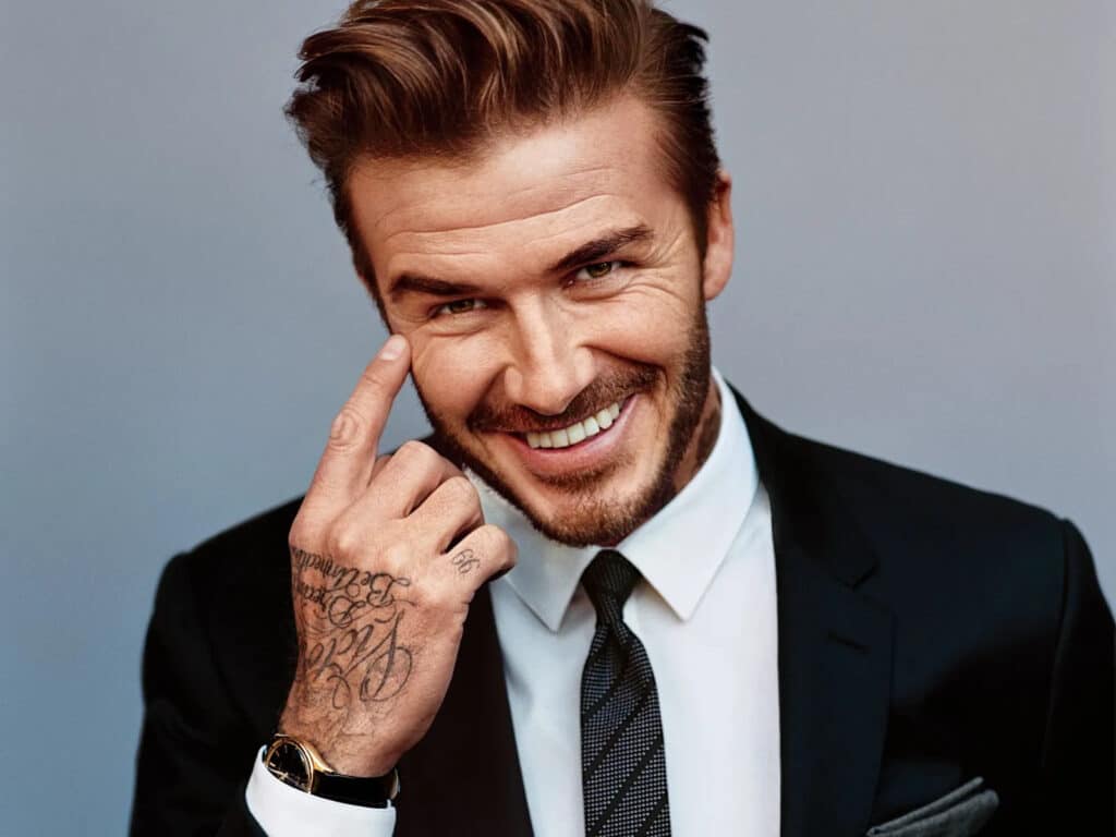 David Beckham smiling in a suit with restored hairline after a possible hair transplant