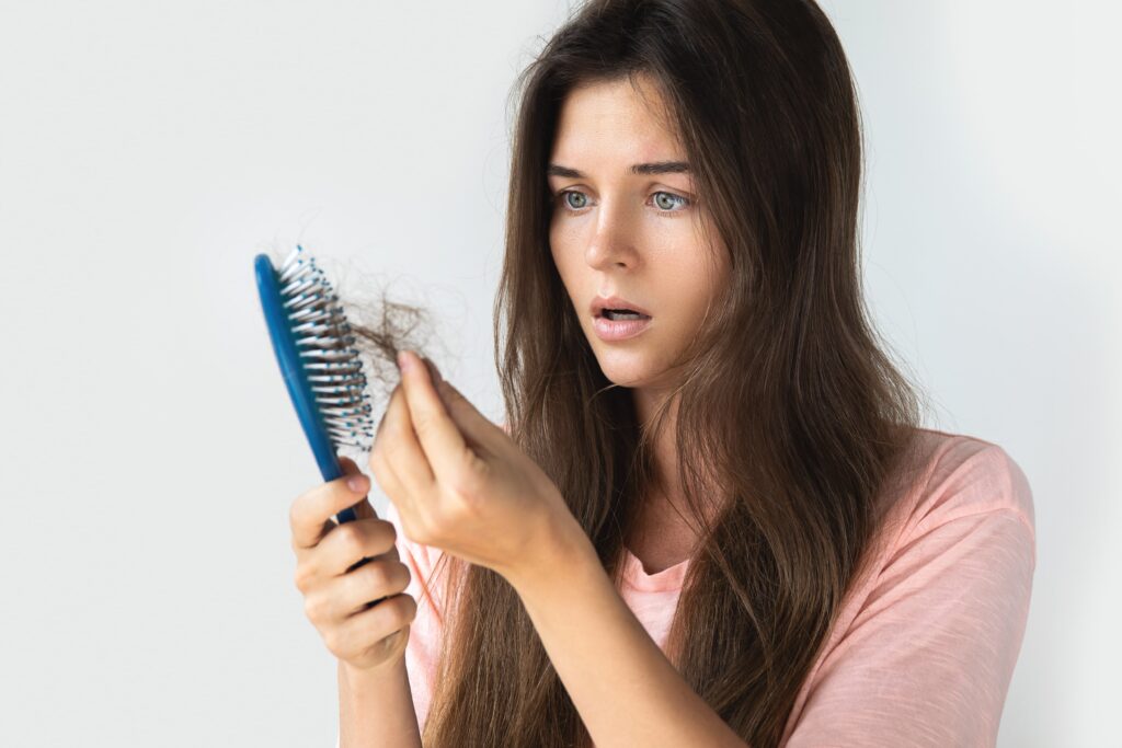 Vrouw die veel haar in haar borstel ziet – op zoek naar het beste haargroeimiddel