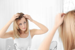 Donna si guarda allo specchio e pensa alla possibilità di avere un trapianto capelli lunghi