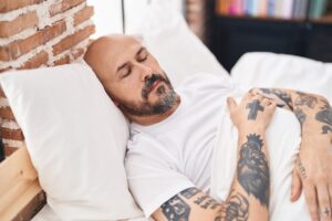 El hombre duerme después de un trasplante capilar.