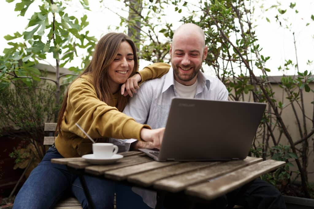 Una pareja se informa mediante un ordenador portátil sobre las relaciones sexuales tras un trasplante capilar.