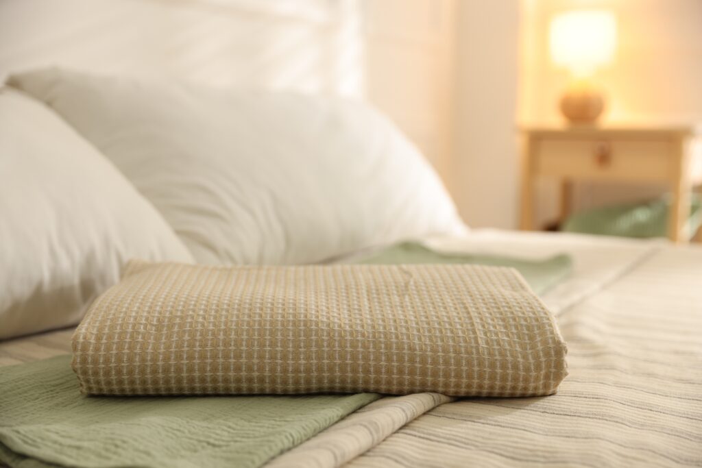 Toalla doblada sobre la ropa de cama