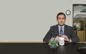Steve Carell after his hair transplant sitting with iconic Best Boss mug