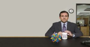Steve Carell siedzący z kubkiem z napisem „Kubek najlepszego szefa na świecie”