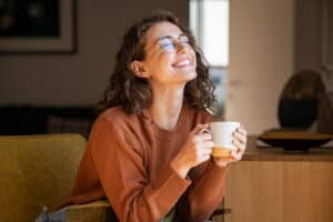Femme souriante savourant une tasse de café