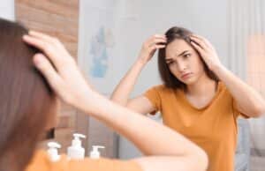 Ragazza con problemi di perdita di capelli si guarda allo specchio considerando un trapianto capelli donne Turchia