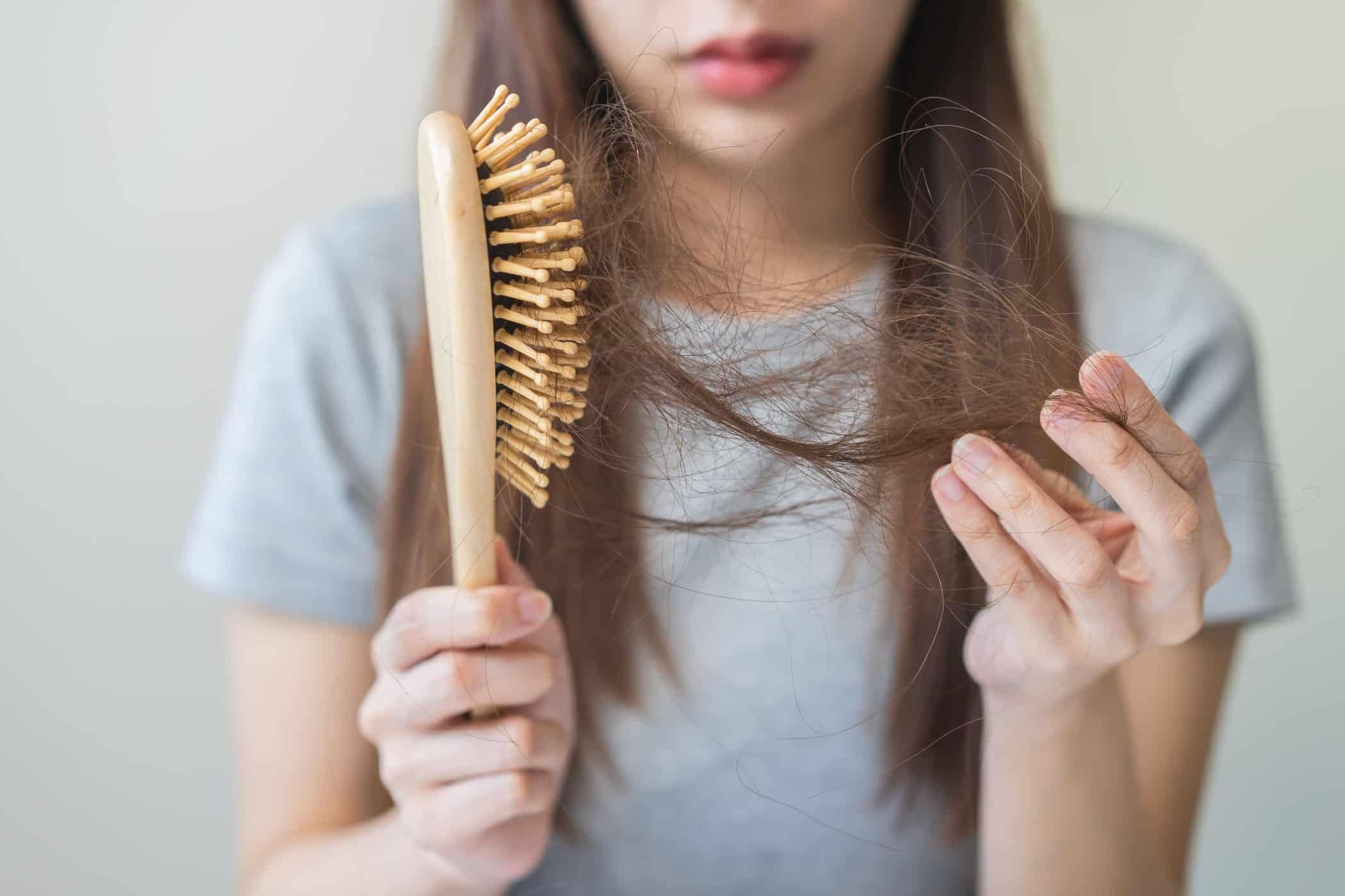 Donna con seri problemi di diradamento capelli stacca i propri capelli da un pettine