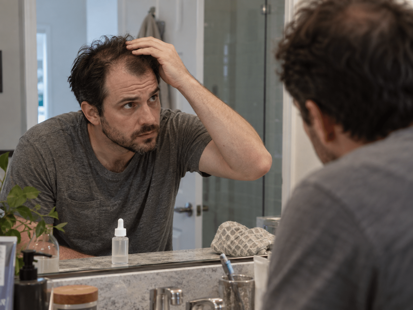 Homme examinant sa perte de cheveux devant un miroir pour illustrer un article sur le PP405