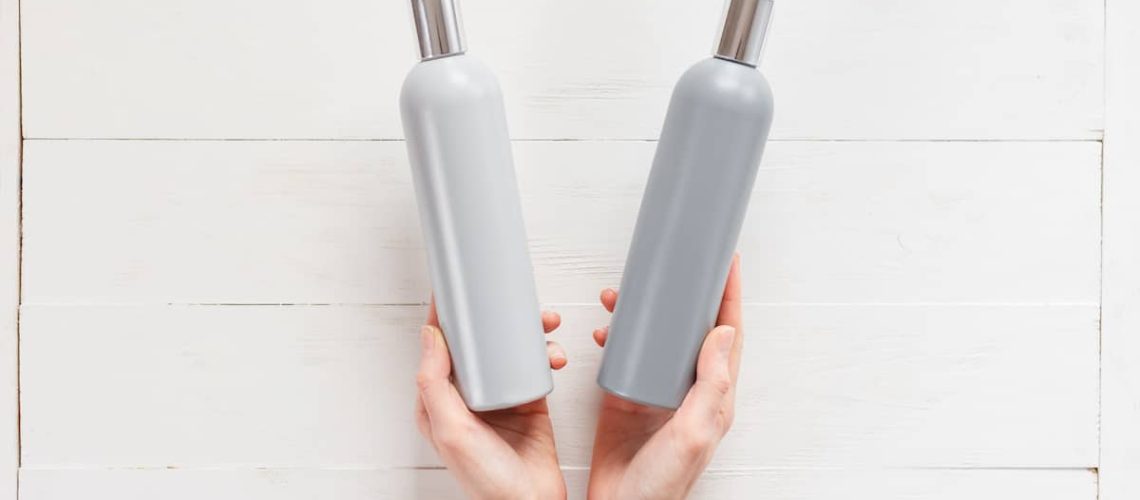 Can the wrong shampoo cause hair loss? A woman holding two shampoo bottles