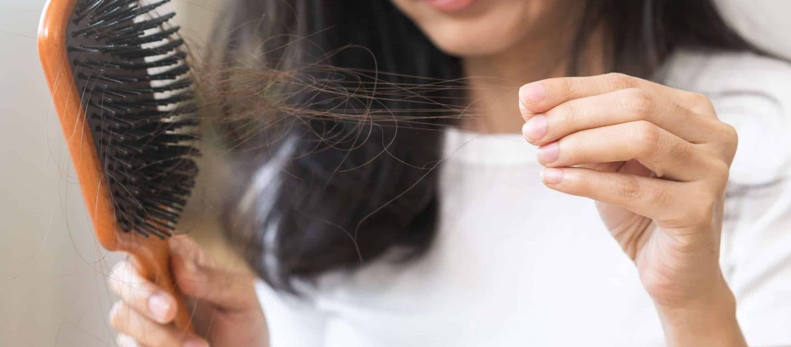 Woman looking at the hairs she's losing