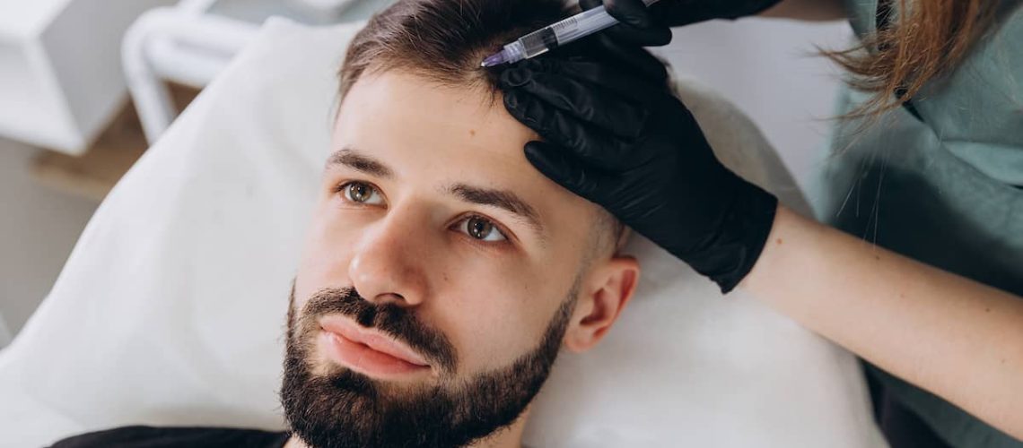 Mężczyzna otrzymujący zastrzyk do mezoterapii na wypadanie włosów